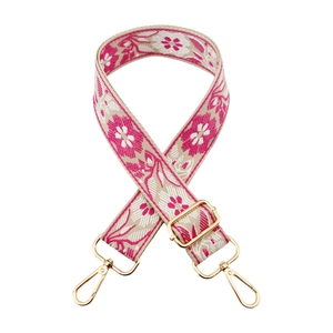 Close-up of pink floral ethnic bag strap with golden rotating metal lobster clasps