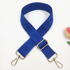 Close-up of dark blue herringbone strap with gold metal hooks and adjustable buckle