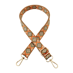 Close-up of adjustable ethnic geometric woven strap with golden lobster clasps for bags