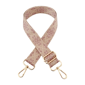 Detail of ethnic geometric patterned wide bag strap with gold metal swivel hooks
