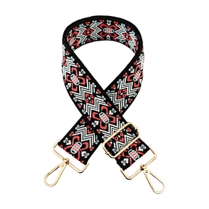 Close-up of thick jacquard woven strap with ethnic patterns and gold metal lobster clasps