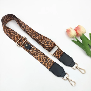Close-up of leopard print bag strap with gold lobster clasps and black leather details