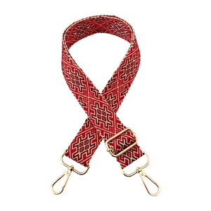 Macro detail of red and beige geometric jacquard guitar strap with gold lobster clasps