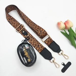 Detail of leopard print crossbody phone strap with gold hardware and transparent mini pouch