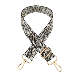 Detail of geometric pattern bag strap with gold metal swivels and adjustment buckle