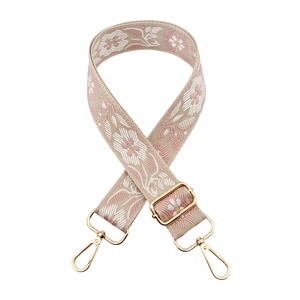 Detail of floral embroidery on wide purse strap with golden metal lobster clasps
