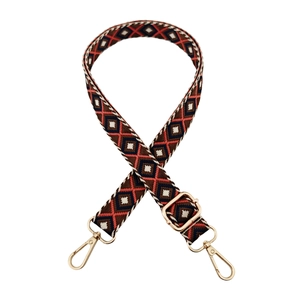 Close-up of ethnic geometric pattern strap with golden metal lobster clasps and buckle