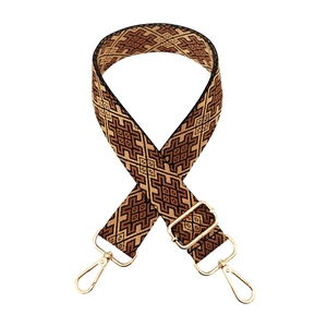 Close-up of bohemian geometric bag strap with adjustable gold-tone buckles on white background