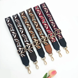 Detail of vintage ethnic jacquard bag straps with leaf embroidery and gold metal buckles
