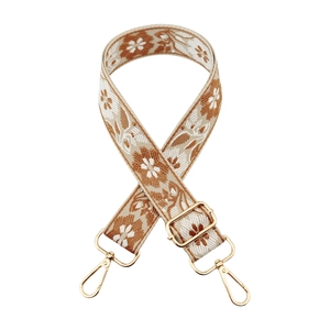 Macro detail of bohemian jacquard flower strap with golden metal lobster clasps