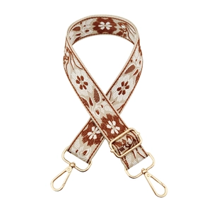 Detailed view of floral jacquard bag strap with gold lobster clasps and metal slider