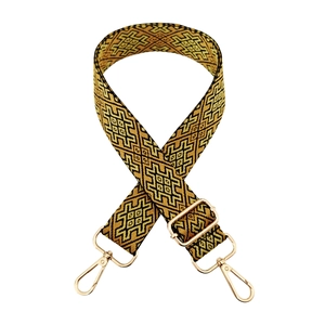 Close-up of ethnic geometric jacquard weaving pattern on wide bag strap with gold metal hooks