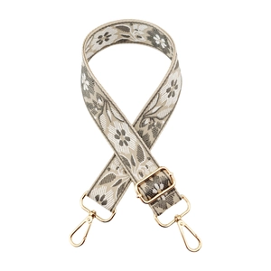 Close-up of vintage floral jacquard bag strap with gold metal lobster clasps and buckles