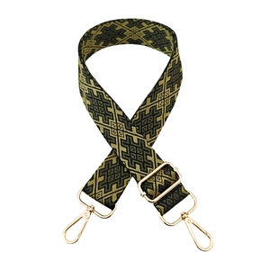 Detail of vintage geometric jacquard woven strap with golden lobster clasps and buckle