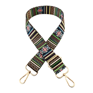 Detail of bohemian patterned wide bag strap with golden metal swivel hooks and buckle