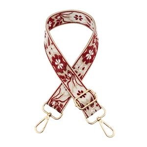 Detail of red and white vintage floral embroidery on wide crossbody bag strap