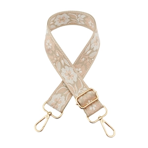 Detail of floral jacquard woven strap with golden adjustable buckle and metal clasps
