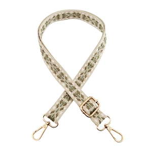 Close-up of geometric woven bag strap with golden buckles and adjustable metal slider