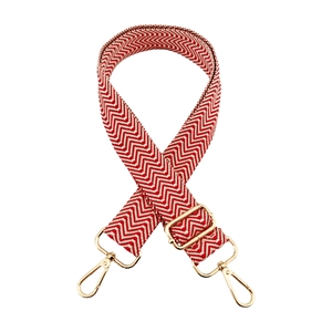 Detail of red and white chevron bag strap with polished gold-tone lobster clasps