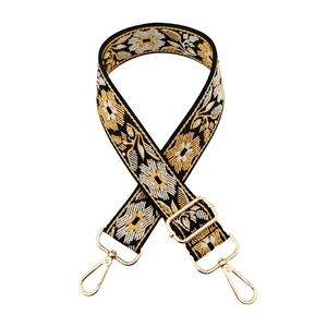 Detail of adjustable floral embroidery bag strap with gold lobster clasps and metal buckle