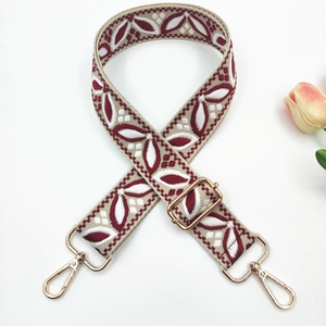 Détail de broderie florale ethnique sur une large bandoulière réglable rouge vin