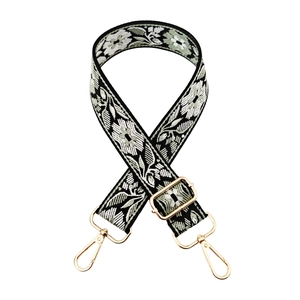 Close-up of ethnic floral embroidery pattern on bag strap with gold metal lobster clasp