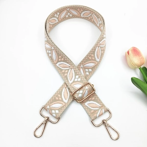 Détail de la bandoulière en jacquard rose avec mousquetons dorés et tulipe