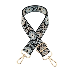 Detail of ethnic floral embroidery on a replacement shoulder strap with gold metal hooks