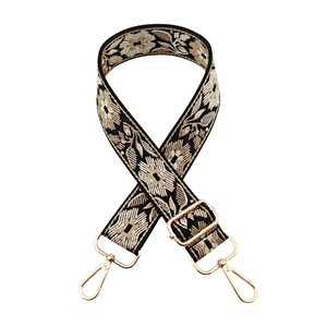 Detail of bohemian floral jacquard bag strap with gold metal buckles and texture