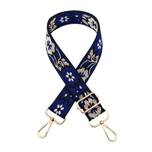 Close-up of ethnic floral jacquard strap with golden metal swivel hooks and adjuster