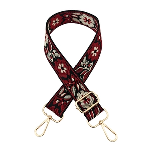 Close-up of ethnic style embroidered bag strap with floral pattern and gold metal hardware