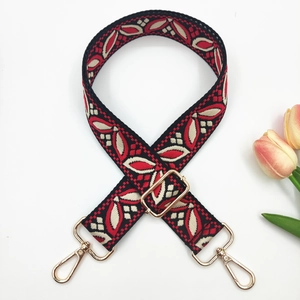Détail d'une bandoulière ethnique en jacquard avec mousquetons en métal doré