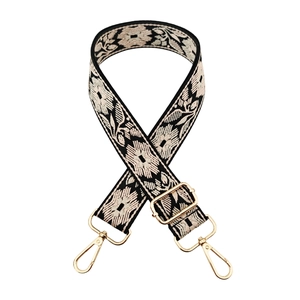 Detail of floral embroidery on wide crossbody strap with gold metal lobster clasps