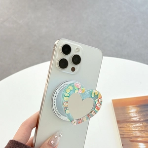 Macro view of heart-shaped phone grip with vibrant fruit patterns on a white smartphone