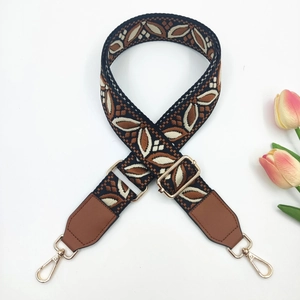 Ethnic style woven jacquard strap with brown leather ends and gold metal hardware
