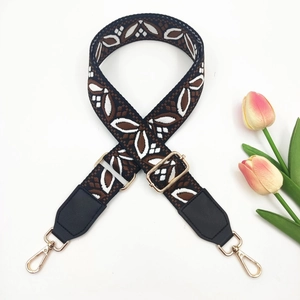 Close-up of ethnic jacquard purse strap with gold hardware and black leather detail