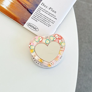 Detail of heart-shaped phone grip mirror featuring fresh lemon and strawberry fruit slices
