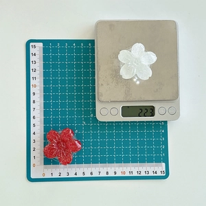 Detail view of flower phone socket grip showing 4cm diameter on a measuring mat