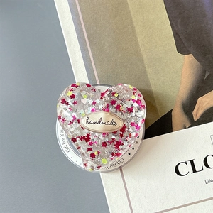 Macro shot of glittery heart phone socket with sequins and handmade metal label detail