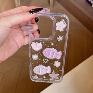 Detail of pink seashell fish and glitter star charms on a clear iPhone case