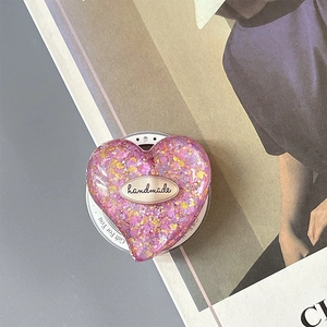 Detail of pink glitter heart phone socket with handmade tag and gift packaging