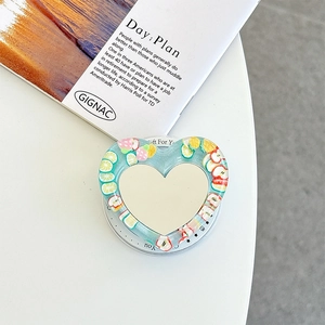 Detail of light blue heart phone stand with fruit slices and built-in makeup mirror