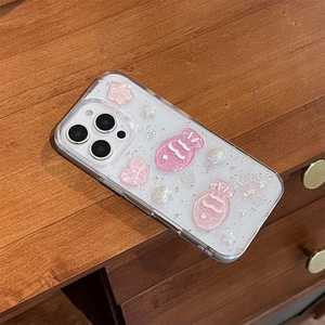 Detail of pink resin fish, pearl shells and silver glitter on transparent phone case