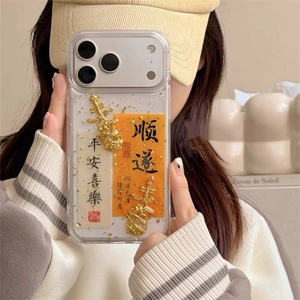 Detail of iPhone case with gold pendants, calligraphy cards, and gold foil flakes