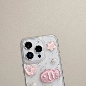 Detail of pink resin fish, hearts and pearls on a glittery iPhone Pro phone case