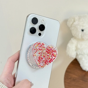 Macro shot of heart-shaped phone grip with glitter, sequins and crystal rhinestones