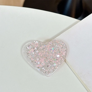 Detailed view of heart-shaped phone grip with pink glitter and star sequins inside