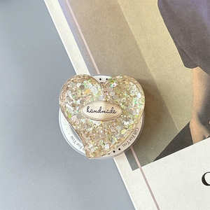 Close-up of heart-shaped glitter phone grip with handmade gold tag and side printing