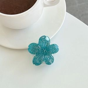 Close-up of cyan floral phone socket with glitter finish on a white background