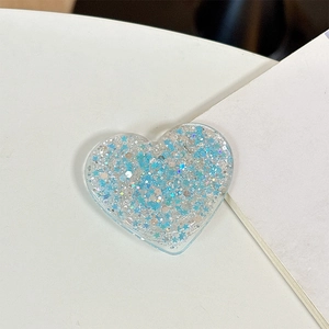 Detail of heart-shaped phone grip with blue and silver glitter flakes in clear acrylic